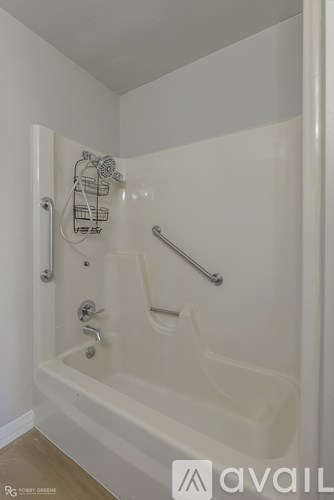 A white bathtub with a glass shower door in a bathroom.