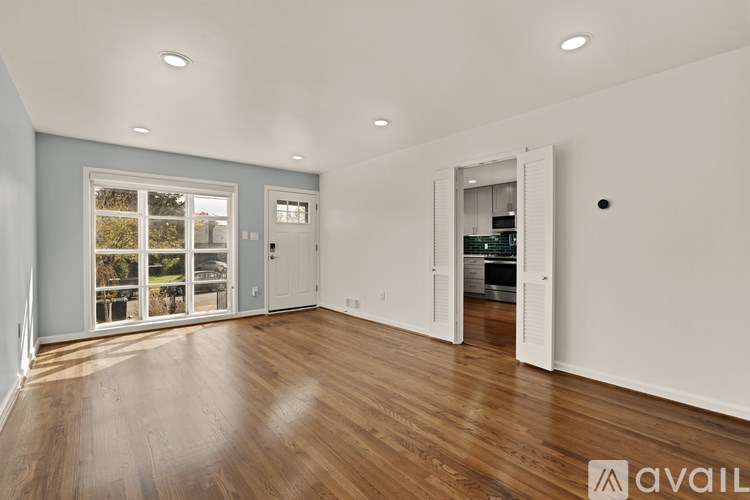 A spacious room with wooden floors and white walls.