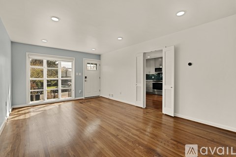 A spacious room with wooden floors and white walls.