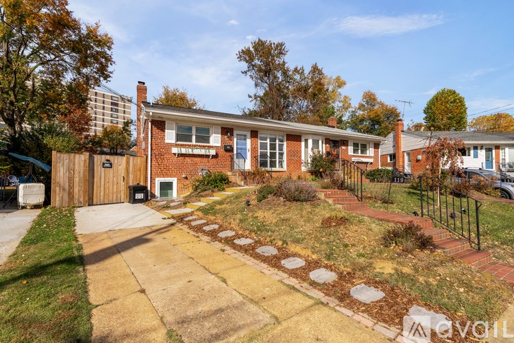 A house with a driveway and a fence in front of it.