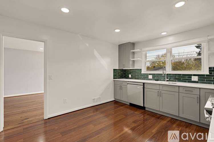 A kitchen with wooden floors and white walls.