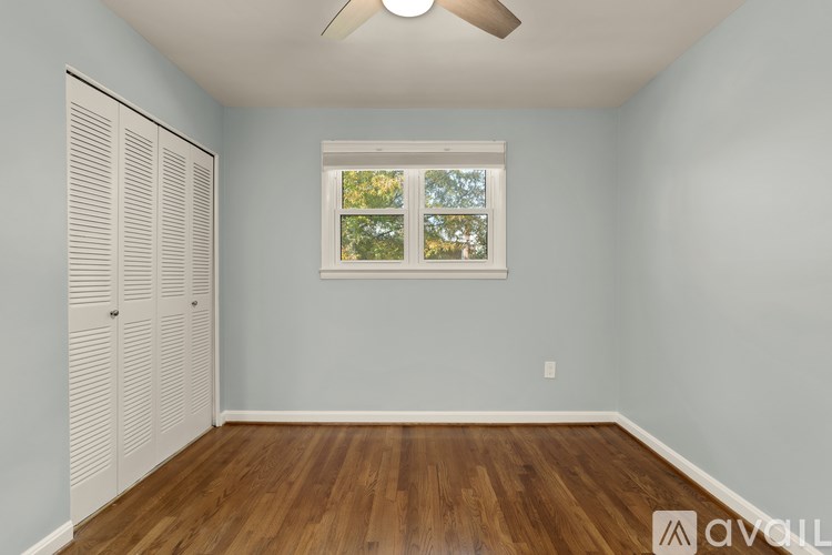 A room with a window and a wooden floor.
