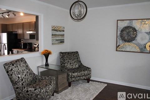 Two chairs and a table with a vase of flowers on it.