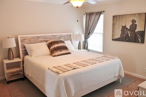 A bedroom with a large bed and a painting on the wall.