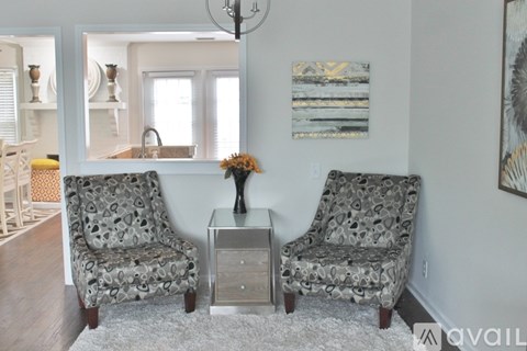 Two chairs and a table with a vase of flowers on it.