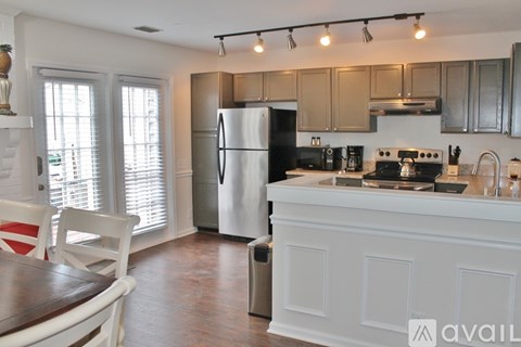 A kitchen with a refrigerator, stove, and sink.
