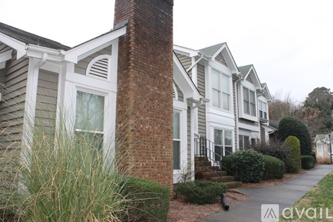 A row of houses with a sign that says "available" in the front yard.