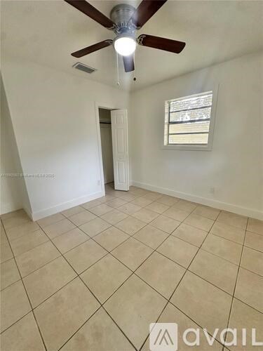 A room with a ceiling fan and a window.