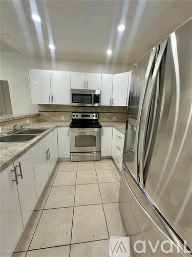 A kitchen with white cabinets and stainless steel appliances.