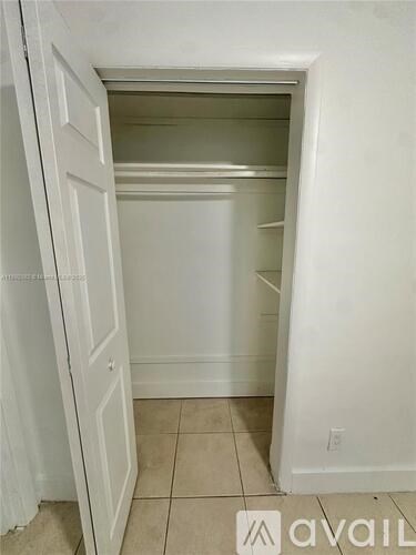 A white doorway leads to a small, empty room.