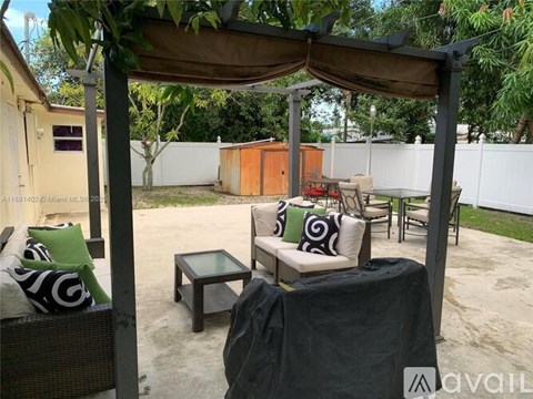 A patio with a table and chairs under a canopy.