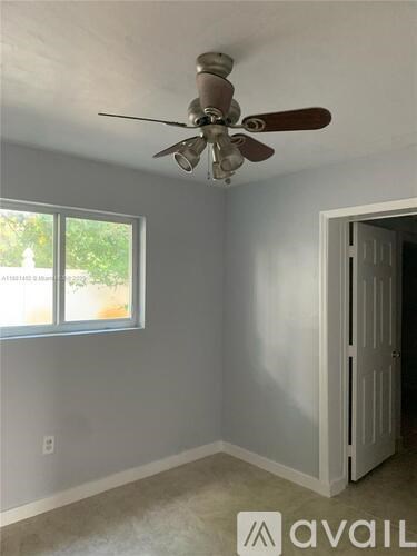 A room with a ceiling fan and a window.