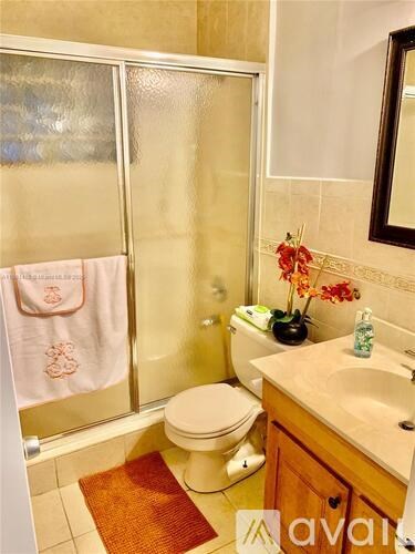 A bathroom with a toilet, sink, and shower.