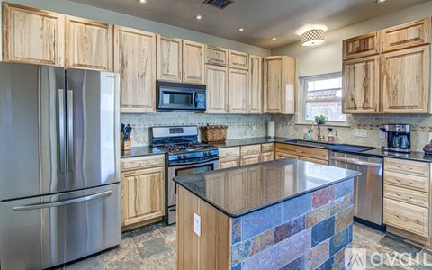 A kitchen with wooden cabinets and a stone counter.