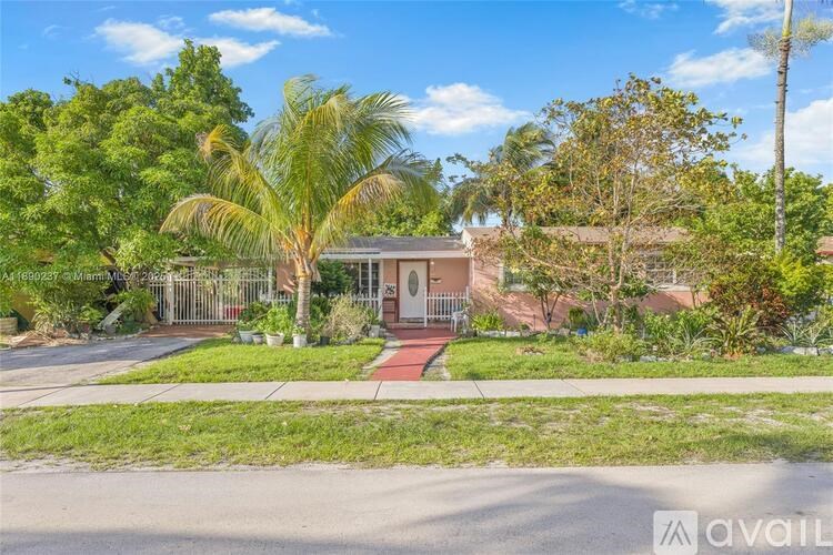 A house with a front yard and a palm tree.