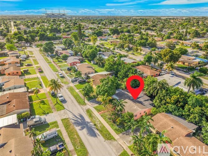 A red pin marks a location in a suburban area with houses and palm trees.