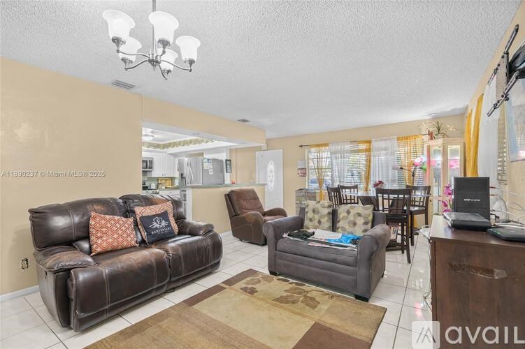 A living room with a brown leather couch and a brown rug.