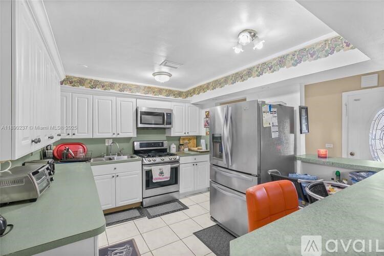 A kitchen with white cabinets and a green countertop.