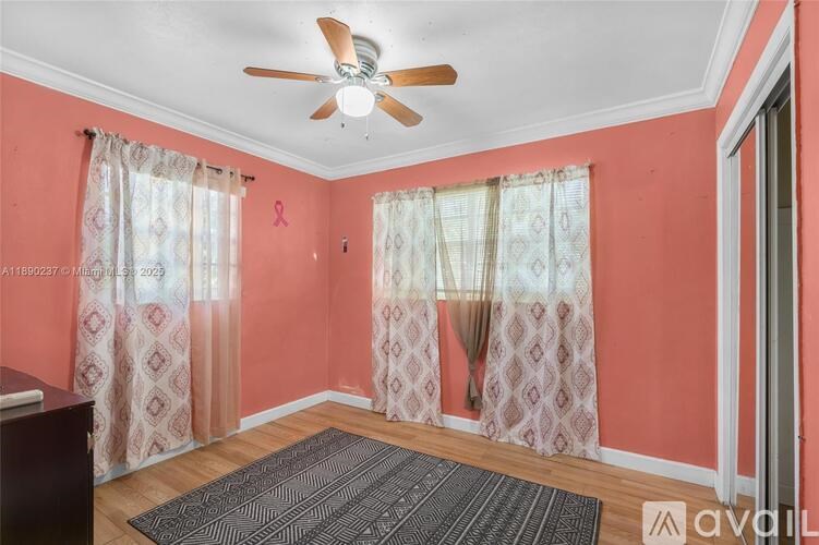 A room with pink walls and a ceiling fan.
