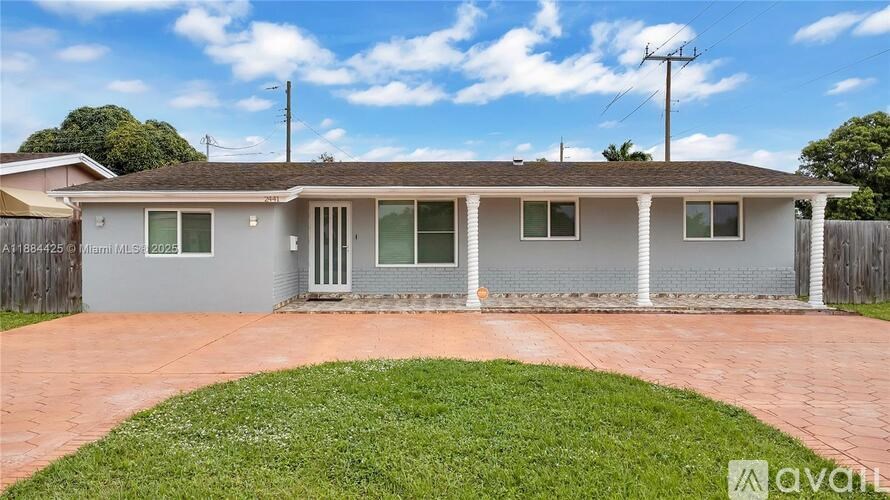 A house with a grey roof and a white wall is for sale.