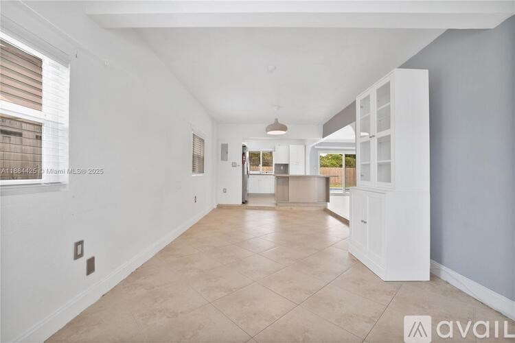 A spacious room with tiled flooring and white walls.