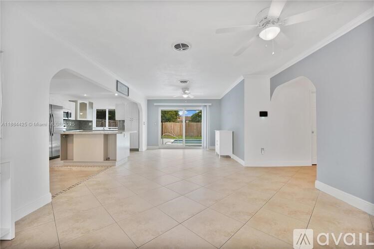 A spacious room with a fan and a large window.