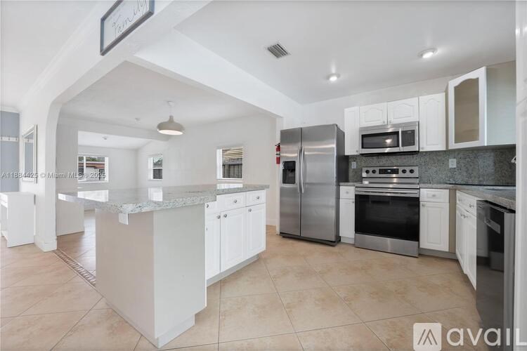 A kitchen with white cabinets and stainless steel appliances.