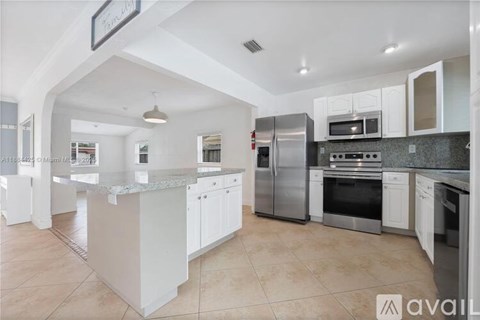 A kitchen with white cabinets and stainless steel appliances.
