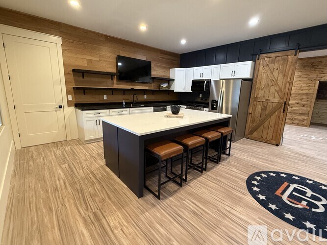 A kitchen with a white countertop and wooden flooring.