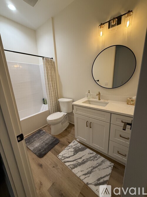 A bathroom with a toilet, sink, and mirror.