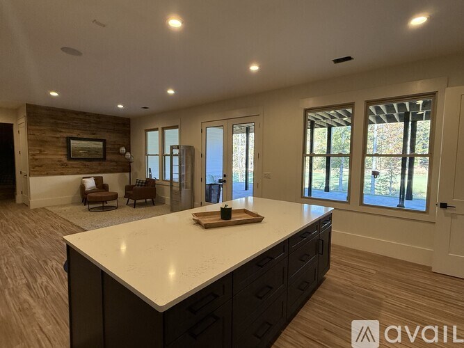 A kitchen with a large island and wooden floors.