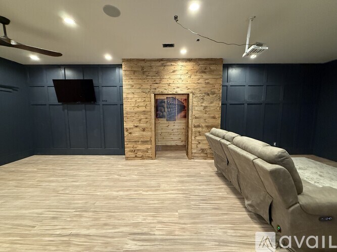 A room with a wooden wall and a bed in the foreground.