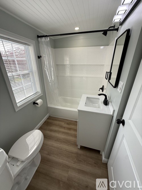 A bathroom with a toilet, sink, and bathtub.