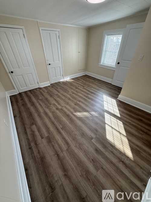 A room with wooden flooring and white doors.