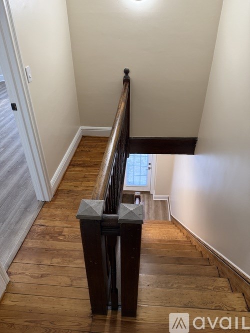A wooden staircase with a metal railing.