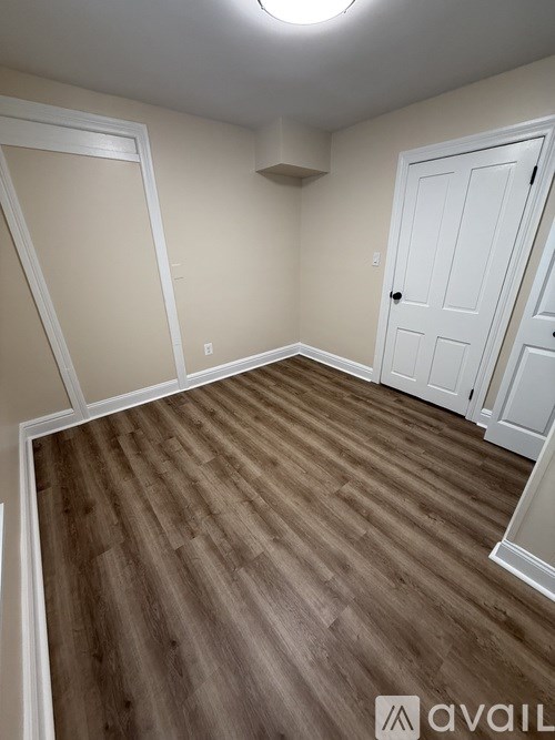 A room with wooden flooring and white walls.