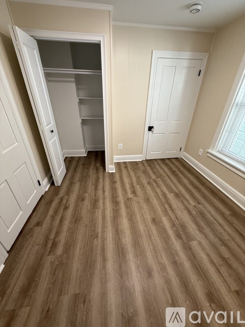 A room with wooden flooring and a white door.