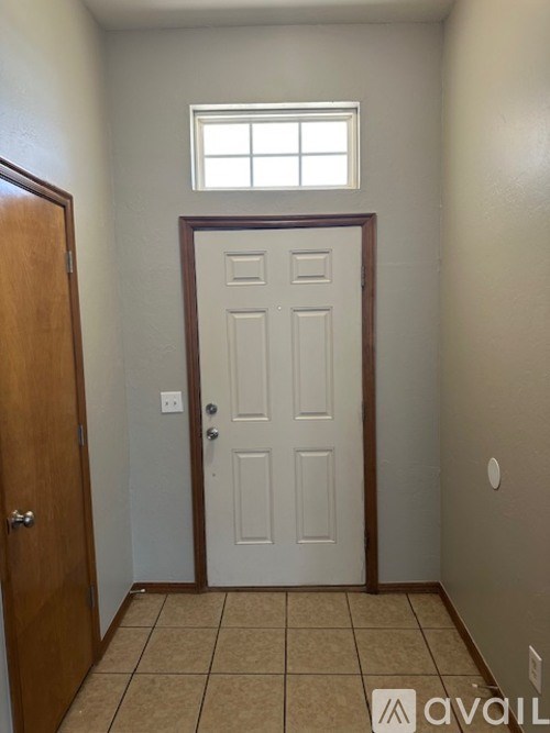 A room with a white door and a window above it.