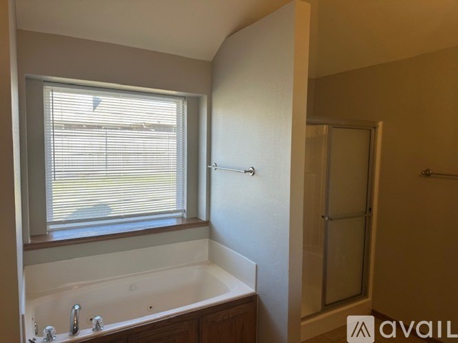 A bathroom with a tub, sink, and window.
