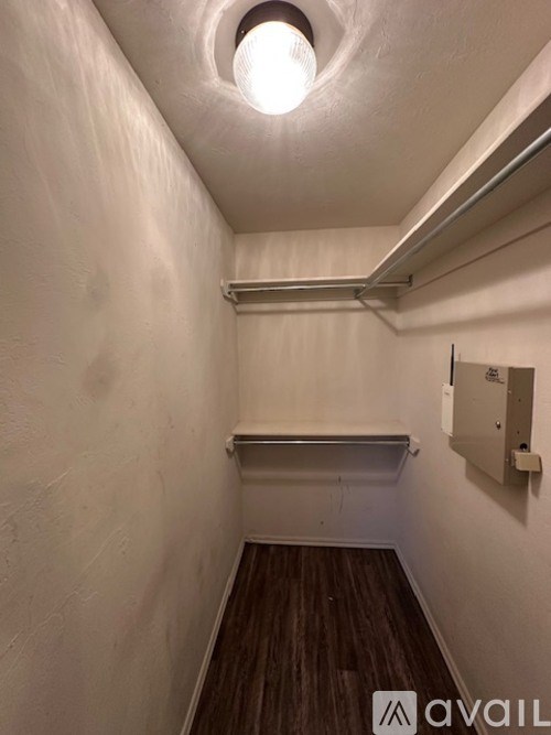 A small, empty room with a light on the ceiling and a white wall.