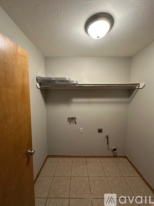 A small, empty room with a shelf and a door.