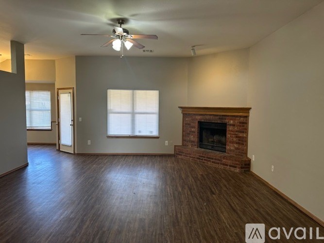 A living room with a fireplace and a ceiling fan.
