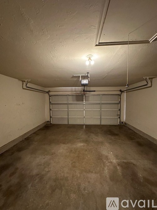 A concrete room with a metal gate and pipes.