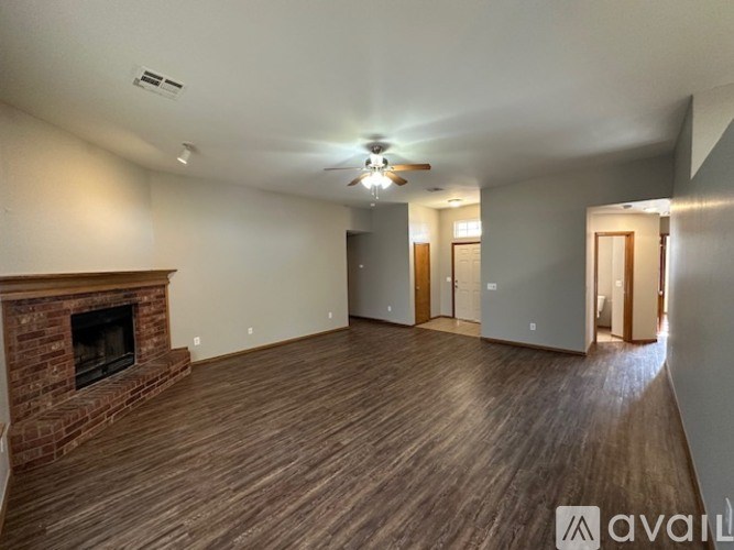 A spacious living room with a fireplace and hardwood floors.