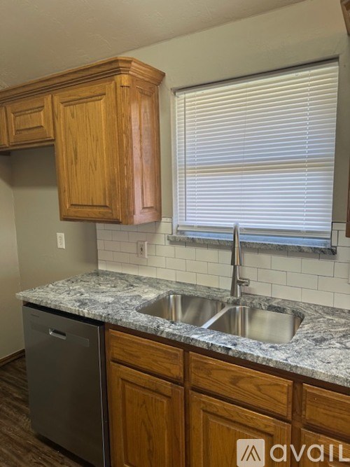 A kitchen with wooden cabinets and a granite countertop.