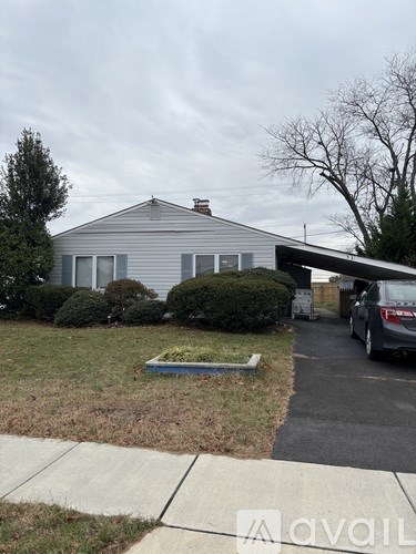 A house with a grey roof and a car parked in front.