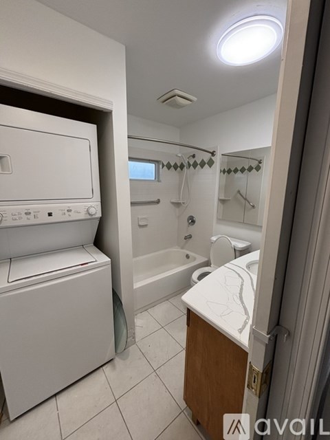A small bathroom with a washer and dryer built in.