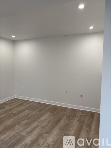 A room with wooden flooring and white walls.