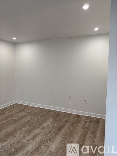 A room with wooden flooring and white walls.