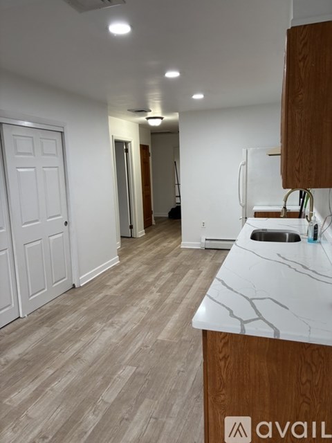 A kitchen with a white counter top and wooden cabinets.
